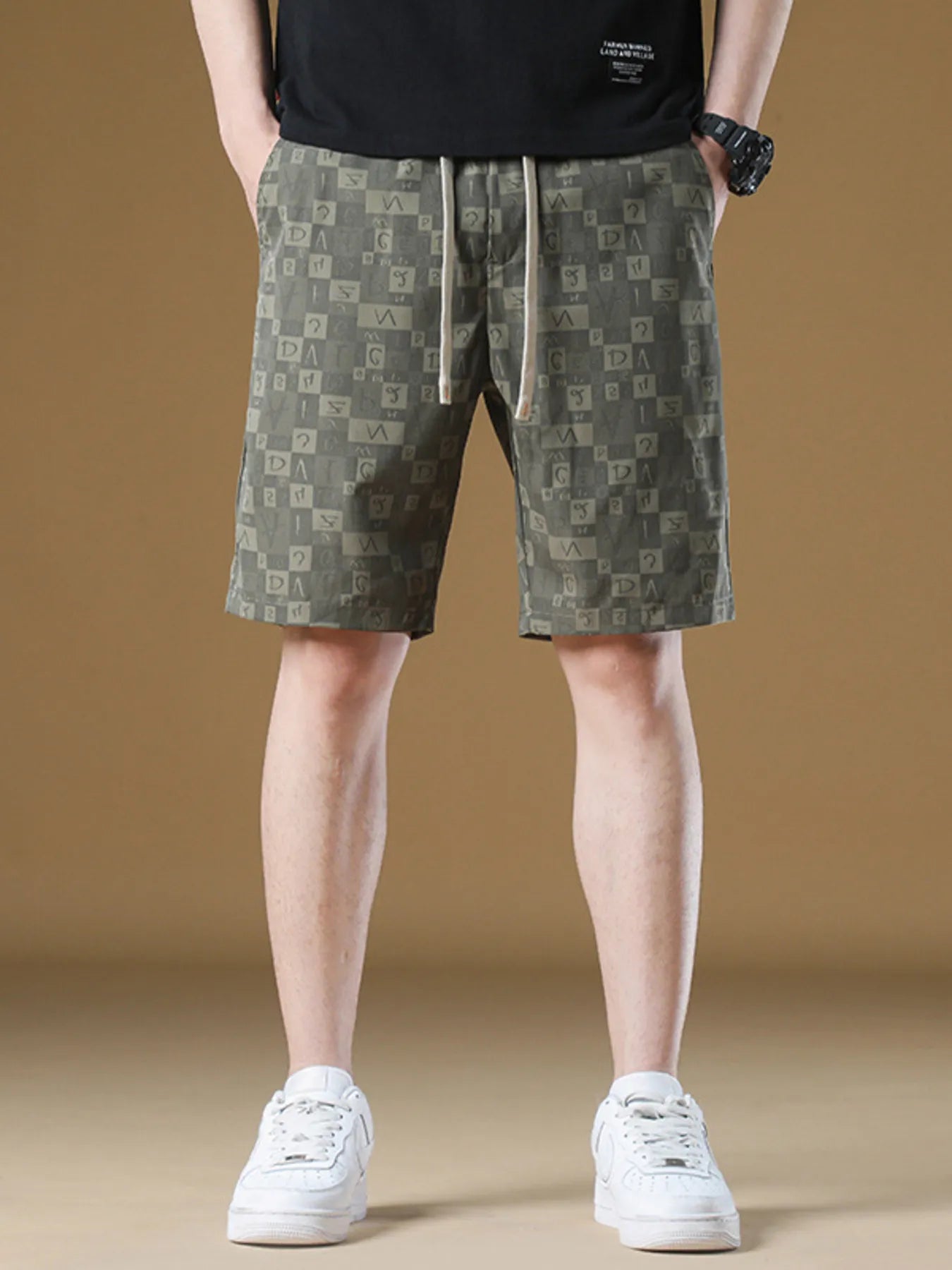 Person wearing patterned shorts and white sneakers on a beige background