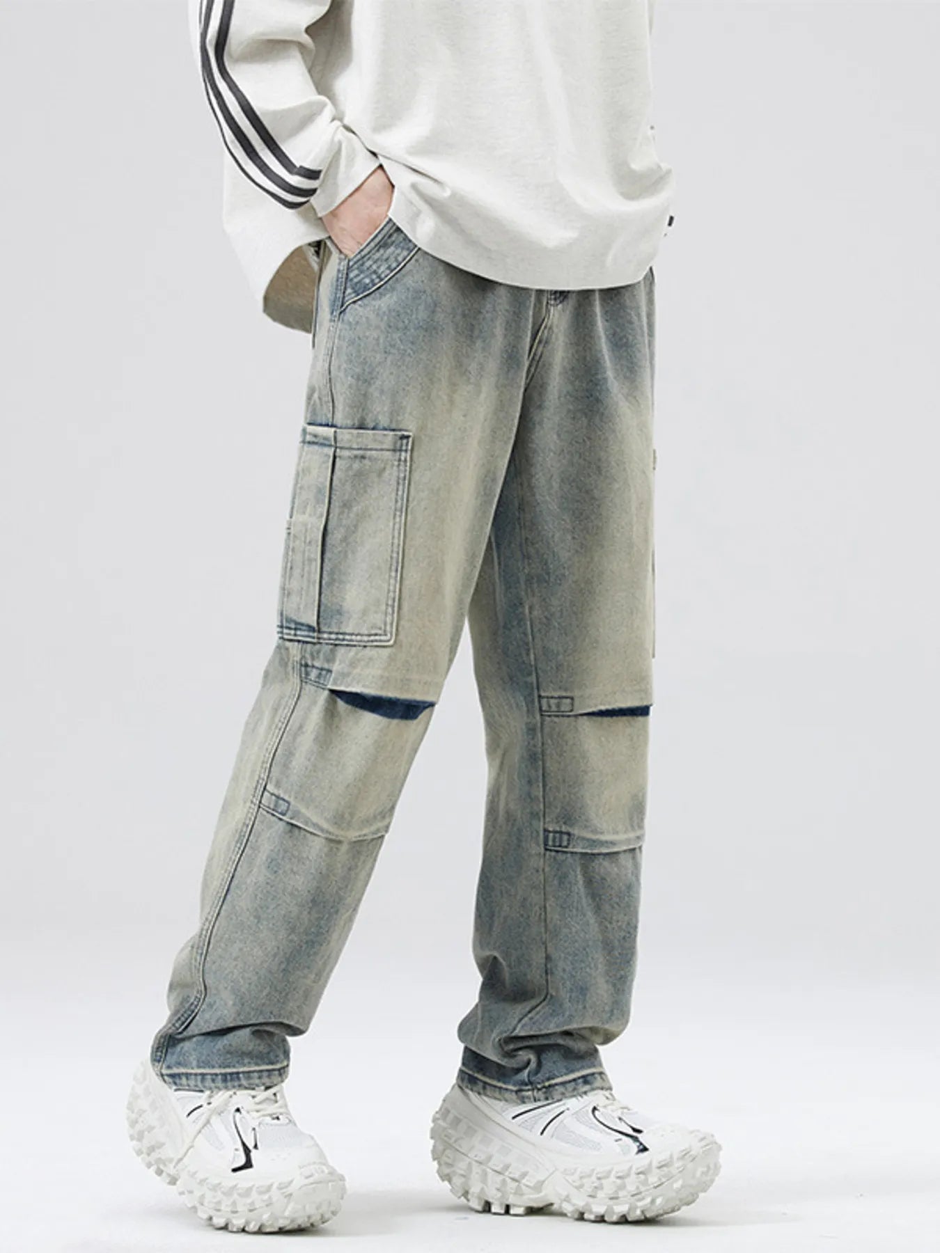 Person wearing light blue patchwork jeans with a white background