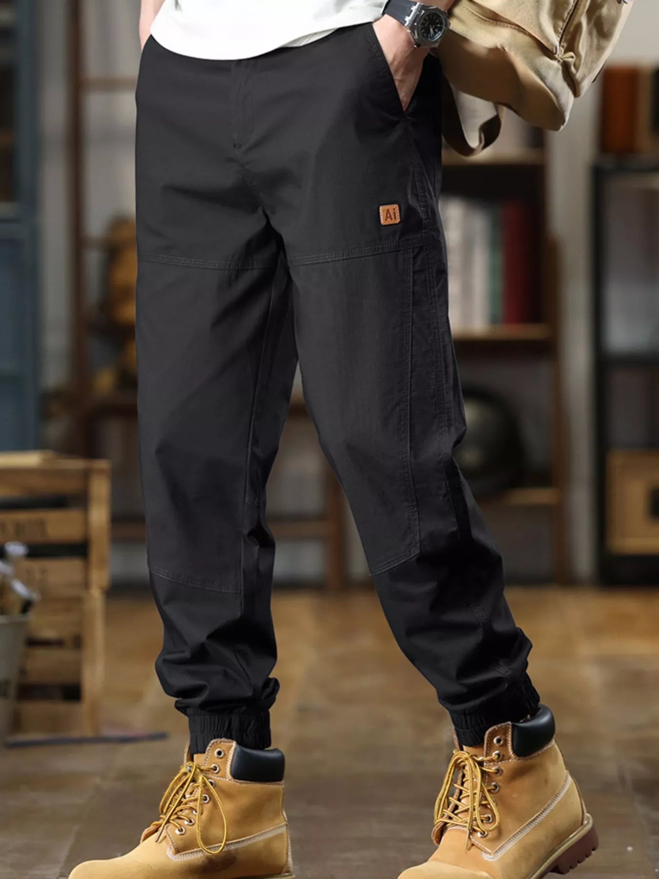 Person wearing black cargo pants and yellow boots in an indoor setting