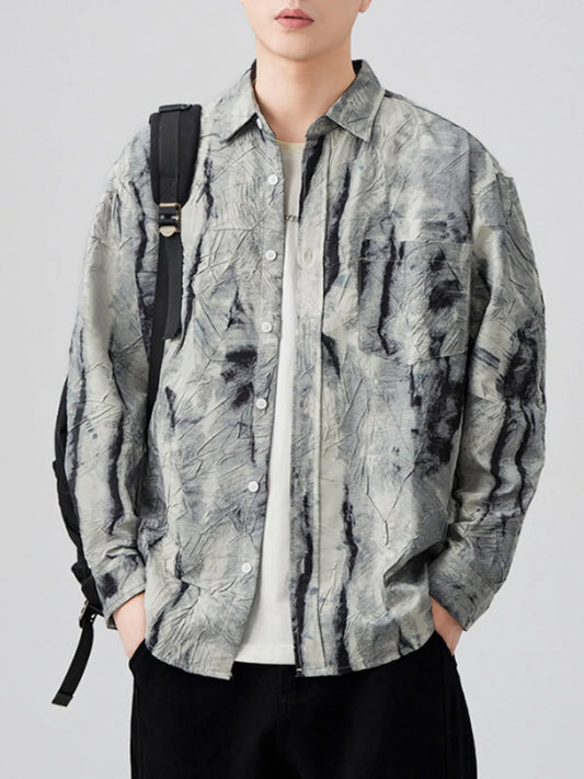 Person wearing a brown and white tie-dye shirt with a backpack on a plain background