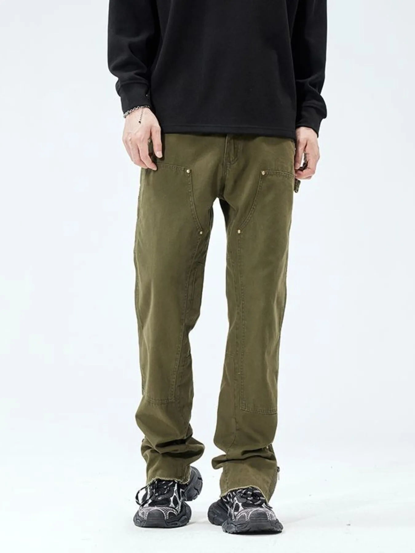 Person wearing olive green pants on a white background