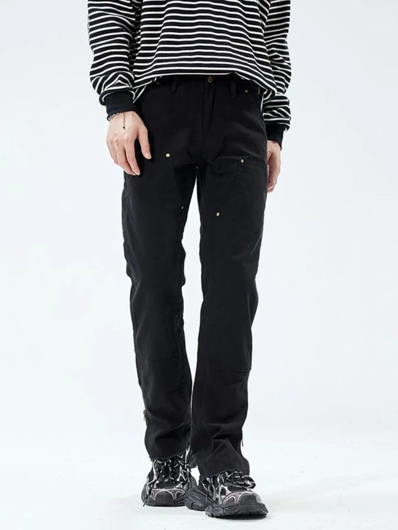 Person wearing black pants and a striped shirt on a white background
