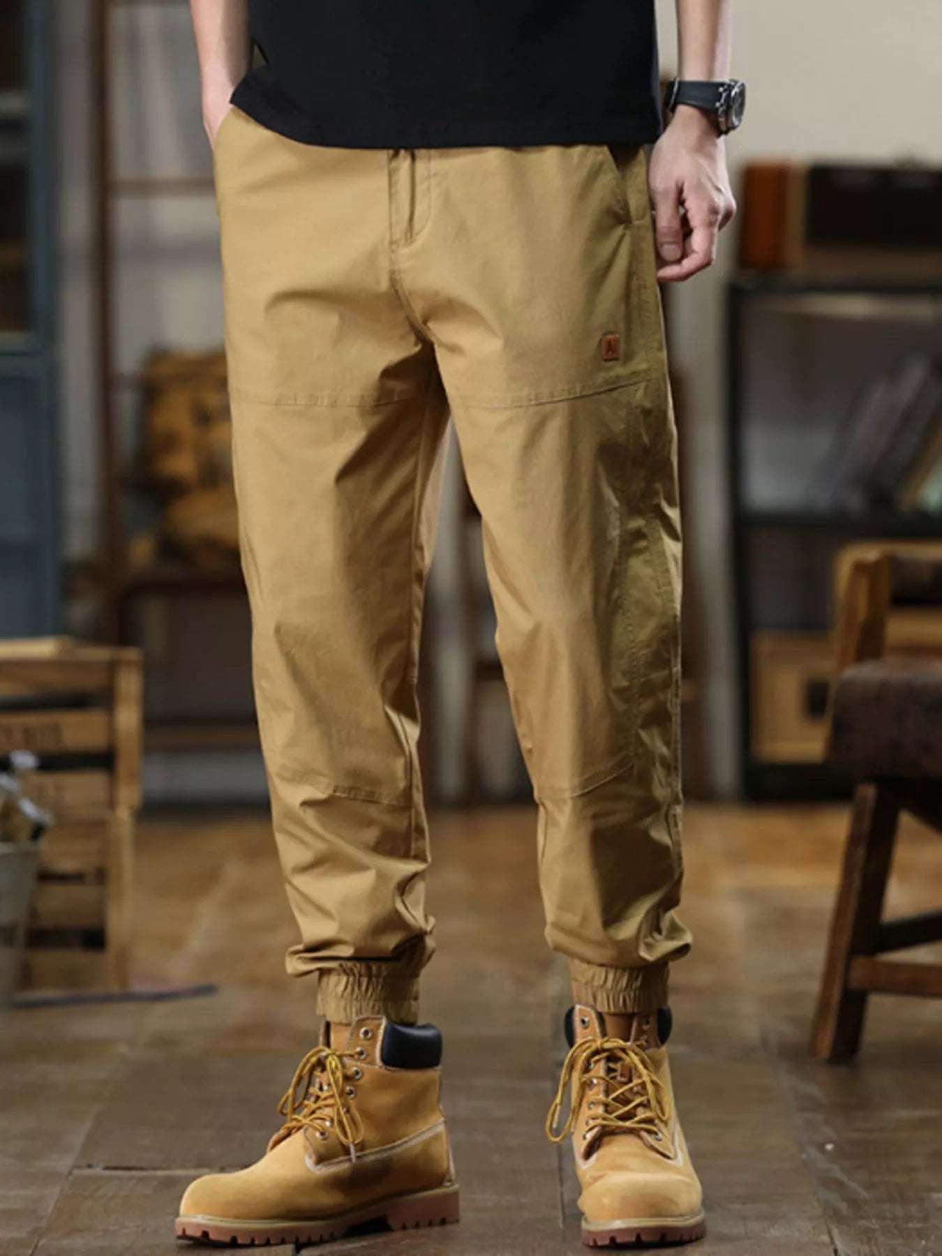 Person wearing tan pants and boots in an indoor setting