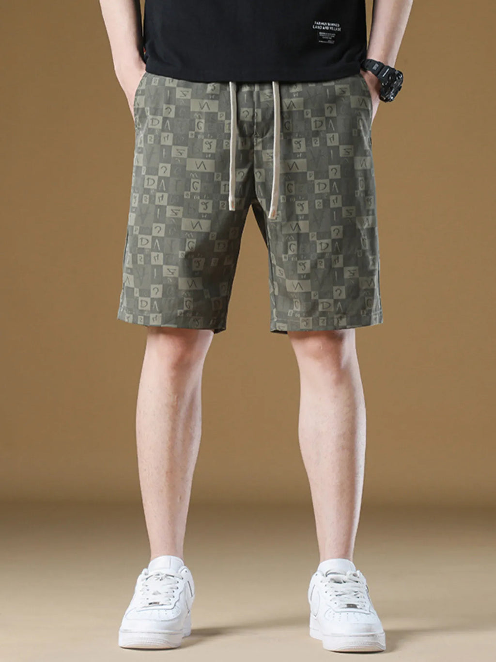 Person wearing patterned shorts and white sneakers on a beige background