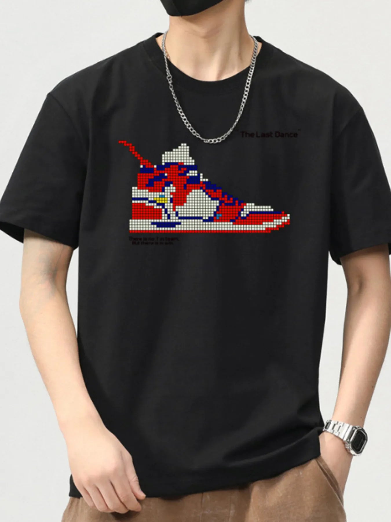 Black t-shirt with a colorful sneaker graphic on a plain background