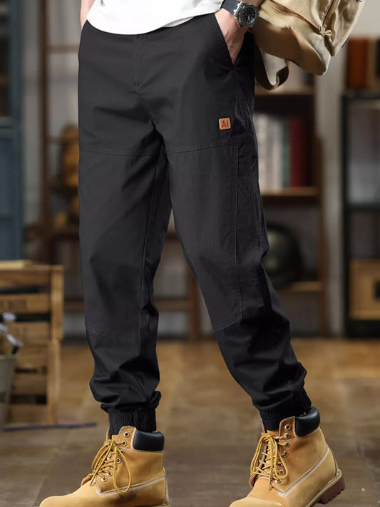 Person wearing black cargo pants and yellow boots in an indoor setting