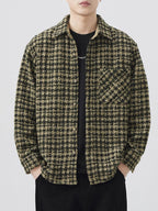 Person wearing a houndstooth patterned shirt over a black t-shirt on a white background