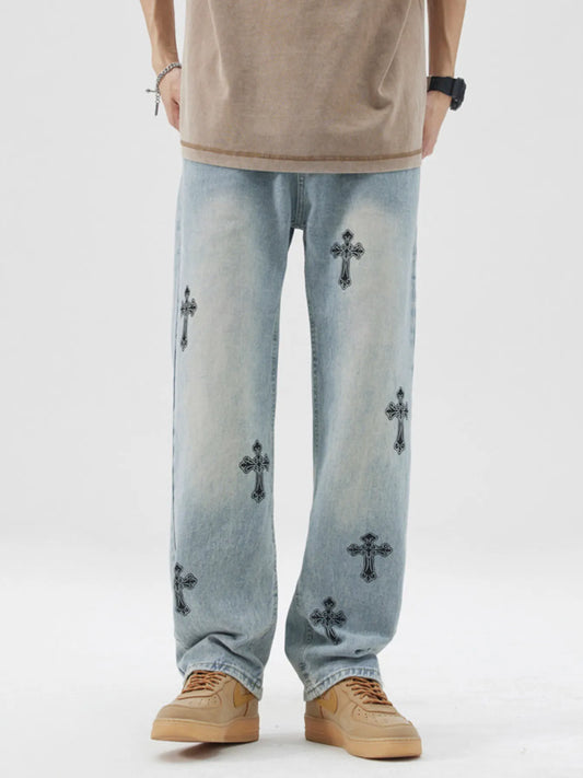Light blue jeans with black cross patterns worn by a person on a white background