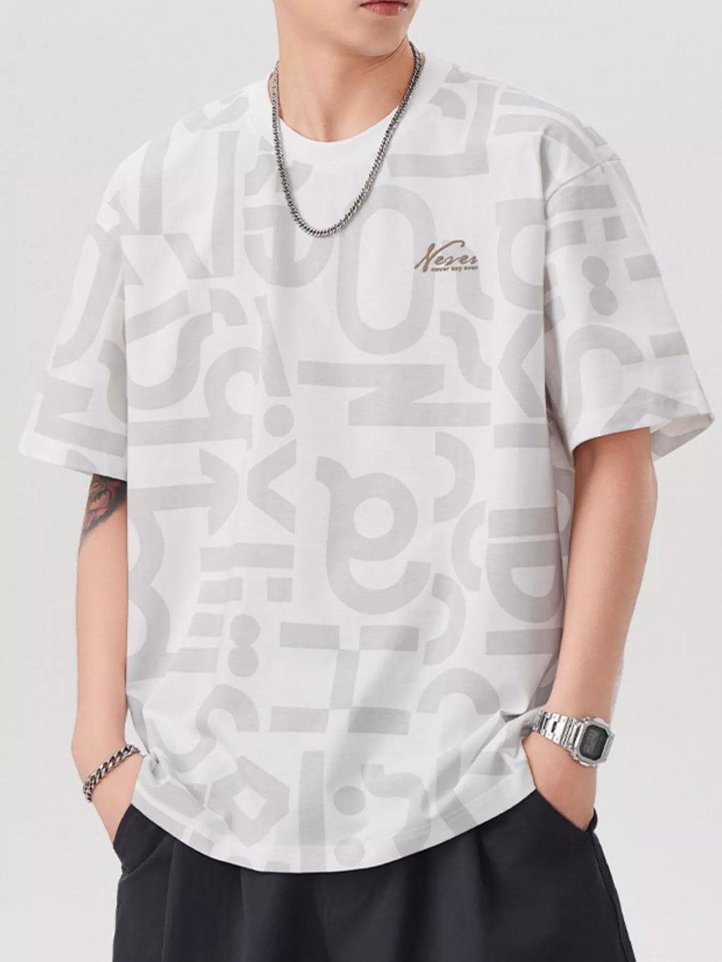 Person wearing a white t-shirt with black text pattern on a plain background