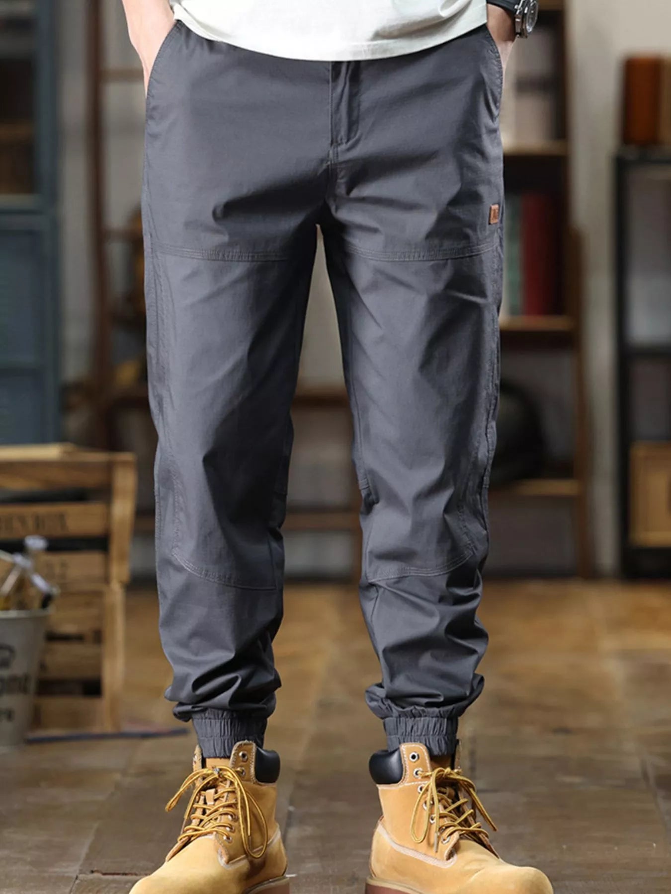 Person wearing gray cargo pants and yellow boots in an indoor setting