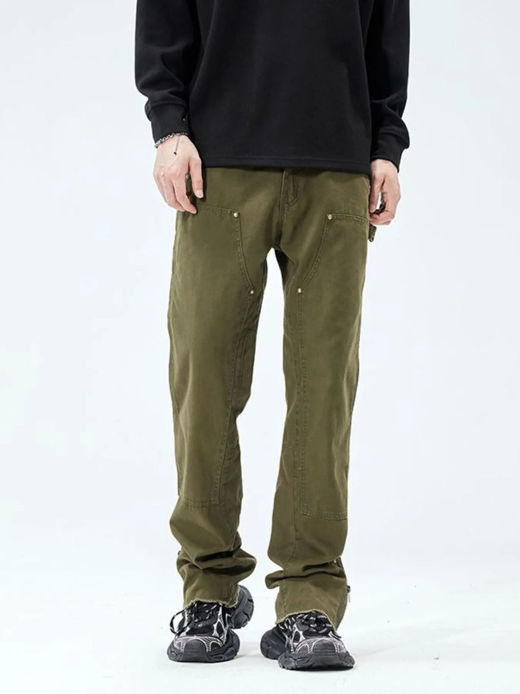 Person wearing olive green pants on a white background