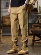 Person wearing beige pants and boots in a room with furniture.