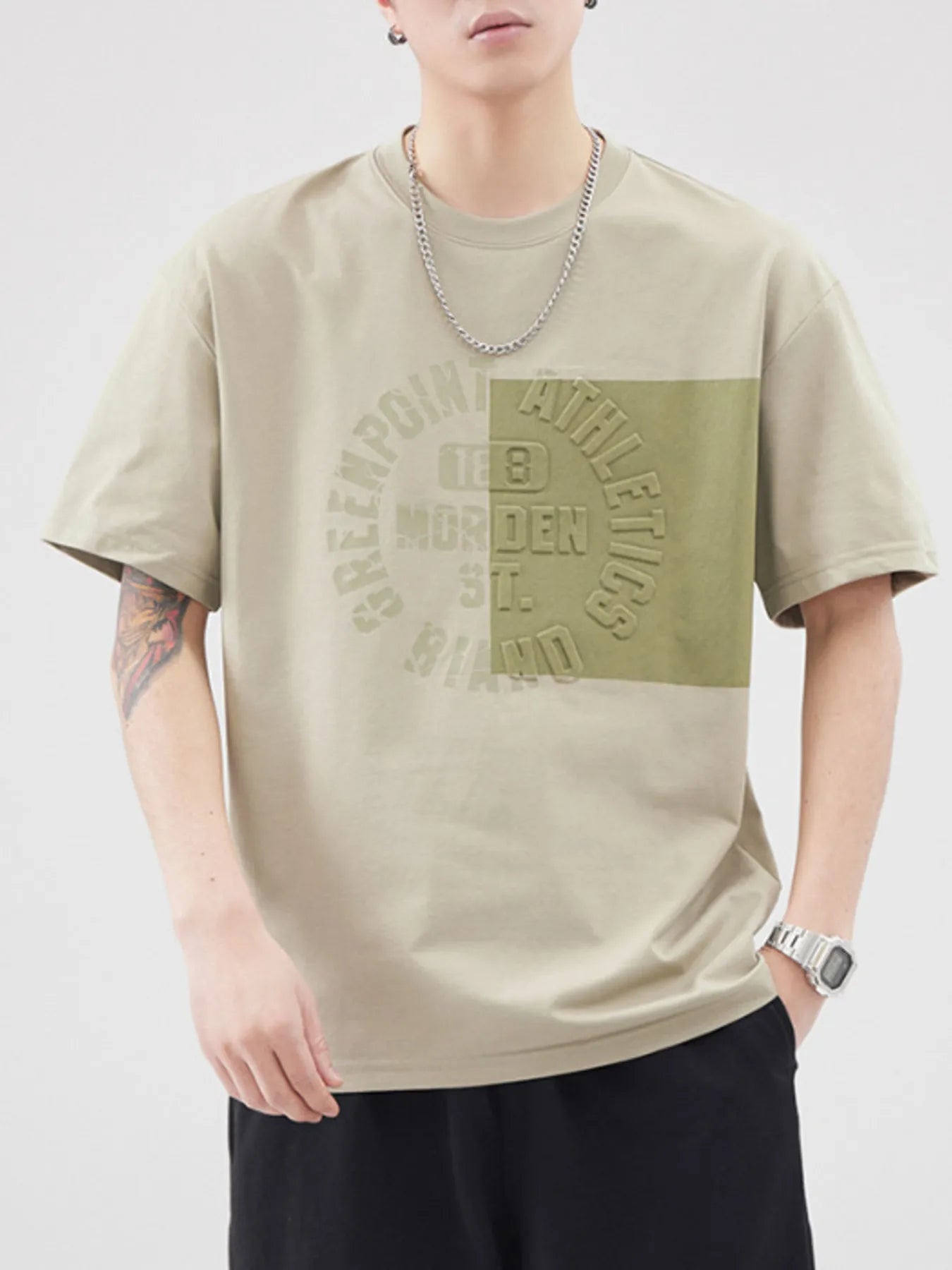 Person wearing a beige t-shirt with a logo and text on a white background