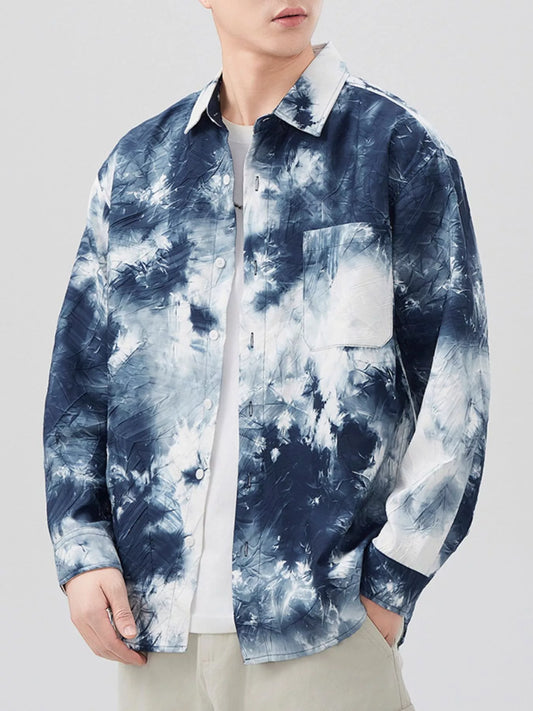 Person wearing a blue and white tie-dye shirt on a plain background