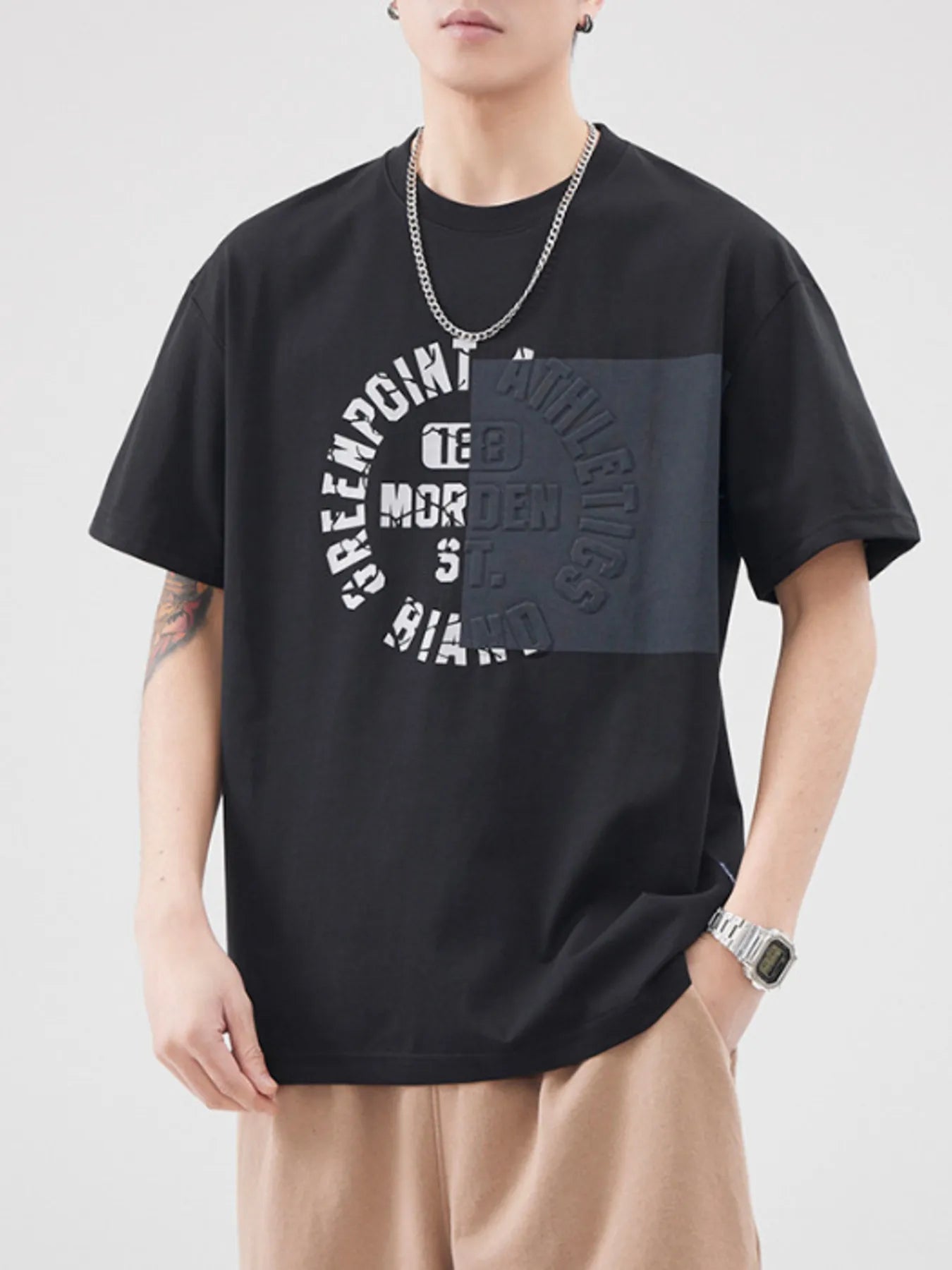 Person wearing a black t-shirt with graphic design on a plain background